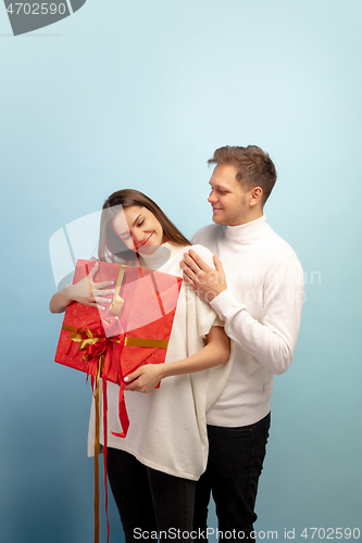 Image of Beautiful couple in love on blue studio background. Valentine\'s Day, love and emotions concept