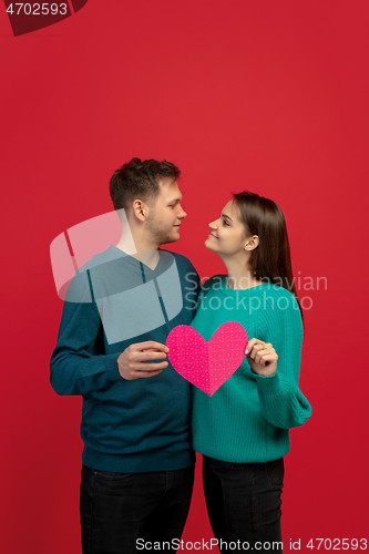 Image of Beautiful couple in love on red studio background. Valentine\'s Day, love and emotions concept