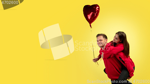 Image of Beautiful couple in love on yellow studio background. Valentine\'s Day, love and emotions concept