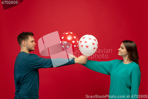 Image of Beautiful couple in love on red studio background. Valentine\'s Day, love and emotions concept