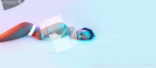 Image of Beautiful female body in the milk bath with soft glowing in blue-pink neon light