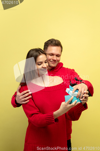 Image of Beautiful couple in love on yellow studio background. Valentine\'s Day, love and emotions concept