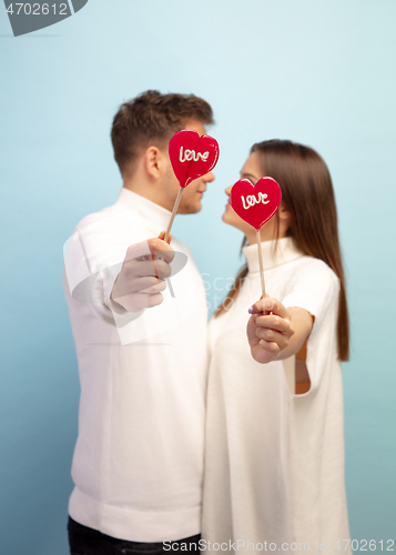 Image of Beautiful couple in love on blue studio background. Valentine\'s Day, love and emotions concept