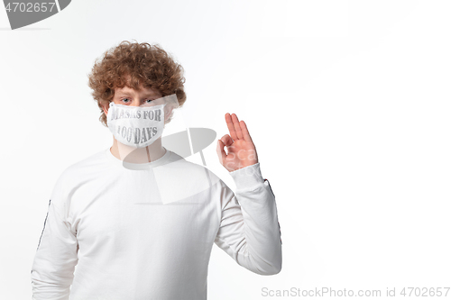 Image of Man wearing protective face mask with sign masks for 100 days in USA, America