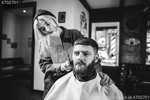 Image of Client during beard shaving in barber shop