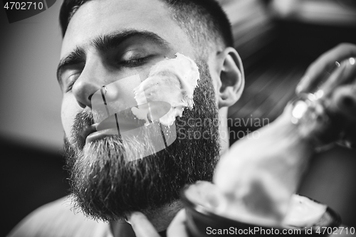 Image of Client during beard shaving in barber shop