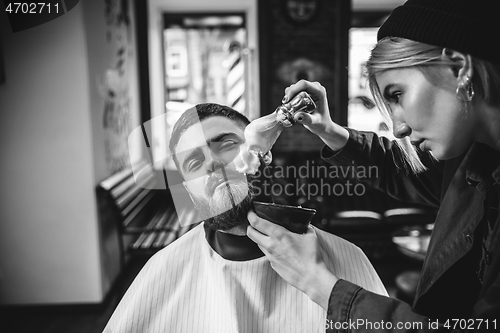 Image of Client during beard shaving in barber shop