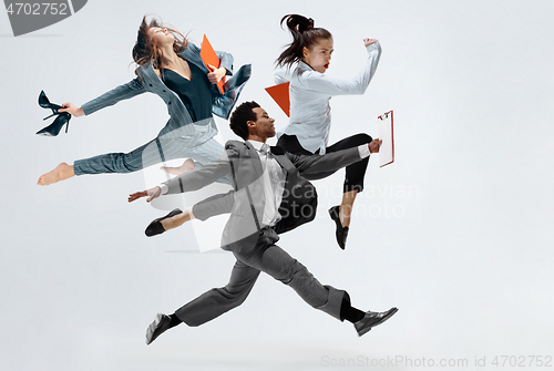 Image of Happy business women and african man dancing isolated on white.