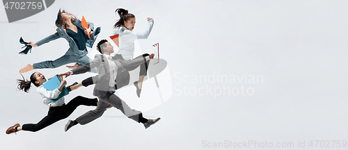 Image of Happy business women and african man dancing isolated on white.