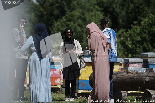 Image of woman giving presentation to group of business investors on local honey production farm