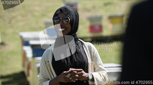 Image of woman giving presentation to group of business investors on local honey production farm