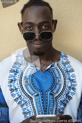 Image of portrait of a smiling young african man wearing traditioinal clothes