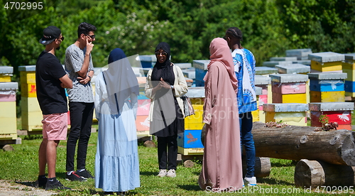 Image of woman giving presentation to group of business investors on local honey production farm