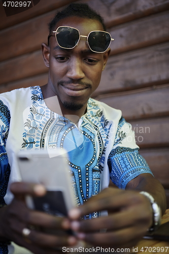 Image of native african black man using smart phone