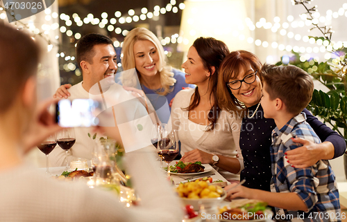 Image of family having dinner party and taking selfie