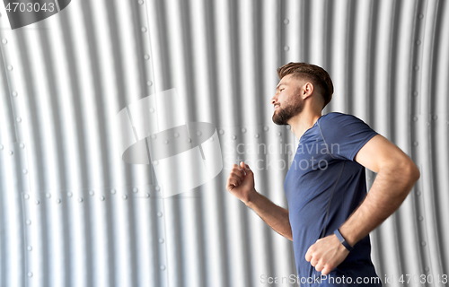 Image of sporty young man running in tunnel