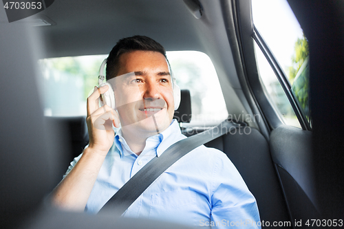 Image of passenger in headphones listening to music in car