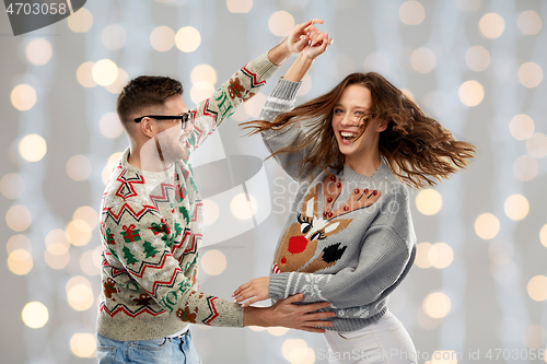 Image of couple dancing at christmas ugly sweaters party