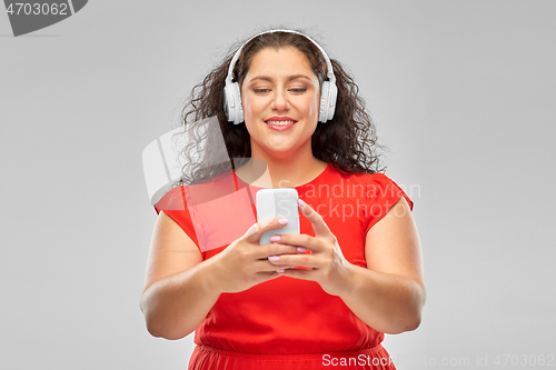 Image of woman in headphones listens to music on smartphone