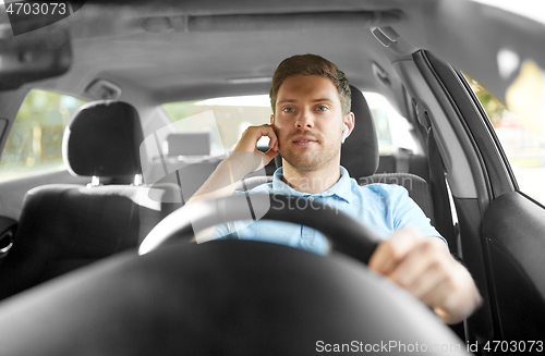 Image of man or driver with wireless earphones driving car