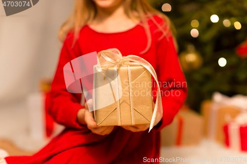 Image of close up of girl with christmas gift at home