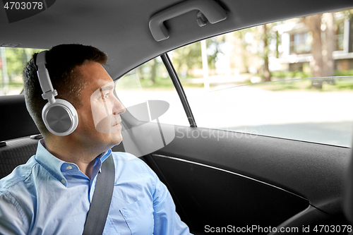 Image of passenger in headphones listening to music in car