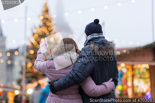 Image of happy senior couple hugging at christmas market