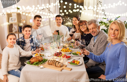 Image of happy family having dinner party at home