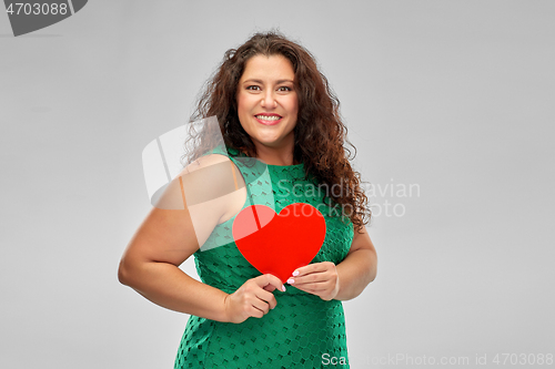 Image of happy woman in green dress holding red heart