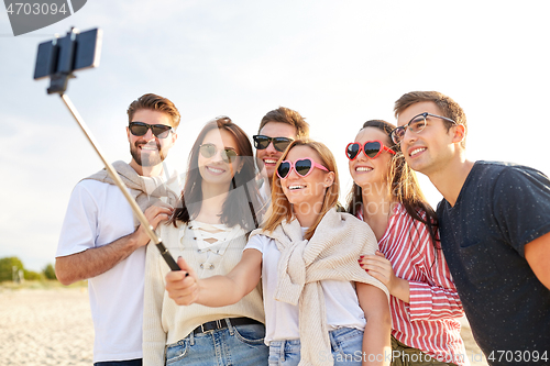 Image of happy friends taking selfie on summer beach