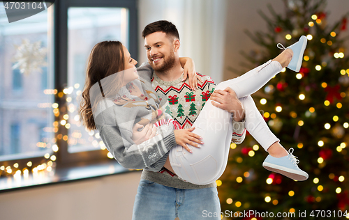 Image of happy couple at christmas ugly sweater party