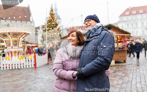 Image of happy senior couple hugging at christmas market