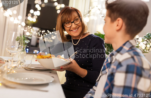 Image of grandmother and grandson having dinner at home