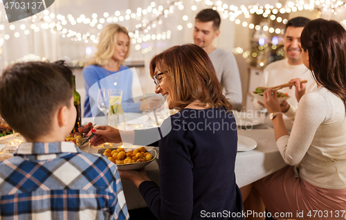 Image of happy family having dinner party at home