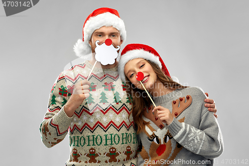 Image of couple with christmas party props in ugly sweaters