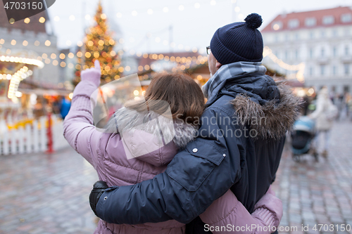 Image of happy senior couple hugging at christmas market