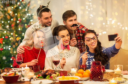 Image of friends taking selfie at christmas dinner