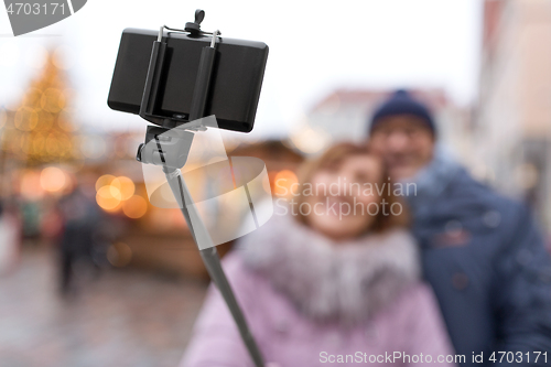 Image of senior couple taking selfie at christmas market