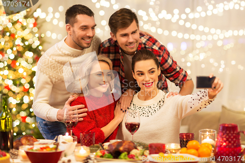 Image of friends taking selfie at christmas dinner