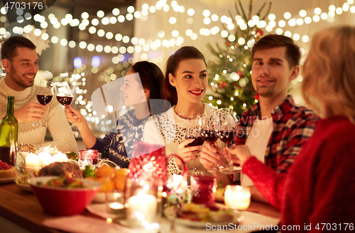 Image of happy friends celebrating christmas at home feast