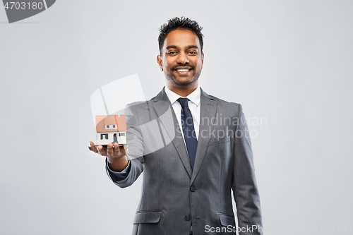 Image of man realtor with house model and folder