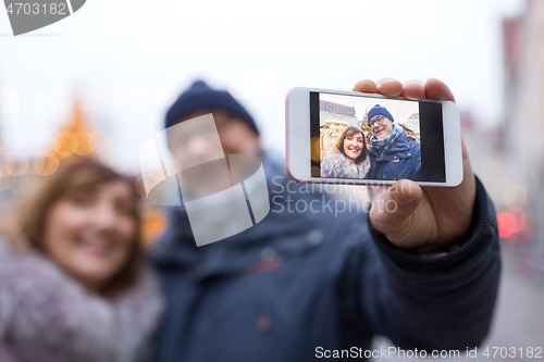 Image of senior couple taking selfie at christmas market