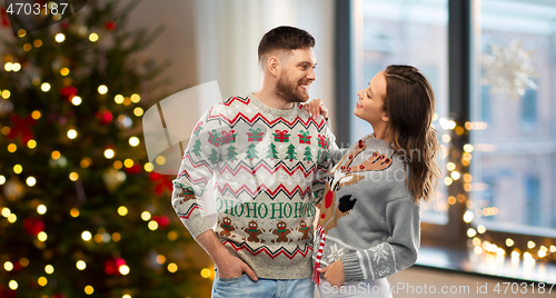 Image of happy couple at christmas ugly sweater party