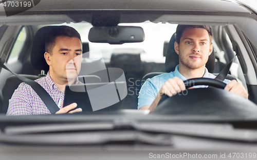 Image of car driving school instructor and young driver