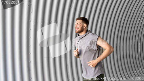 Image of sporty young man running in tunnel