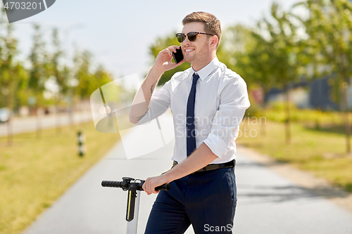 Image of businessman with scooter calling on smartphone