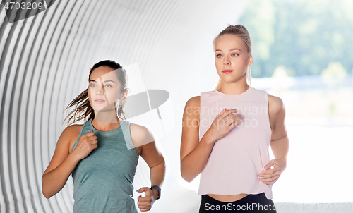 Image of young women or female friends running outdoors