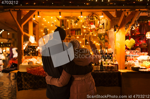 Image of happy senior couple hugging at christmas market