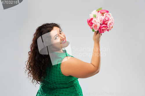 Image of happy woman in green dress with flower bunch