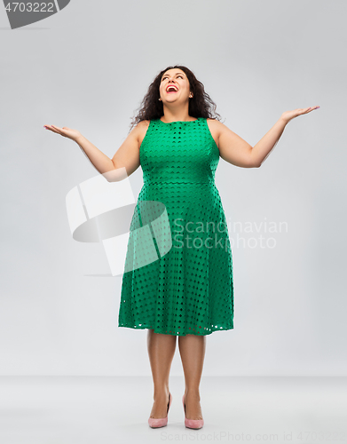 Image of happy smiling woman in green dress looking up